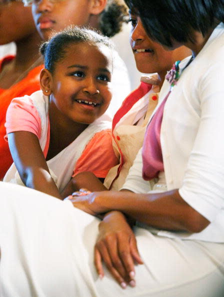 Younger daughter Sasha (L) talks with first lady Michelle Obama (R) daughter Malia (C) looks on during a concert at the East Room of the White House June 15, 2009 in Washington, DC. The first lady launched the White House music series with a jazz studio including a classroom session and a concert featuring Wynton Marsalis, Paquito D'Rivera and Tony Madruga. Obama's other also attended the event. (Photo by Alex Wong/Getty Images)