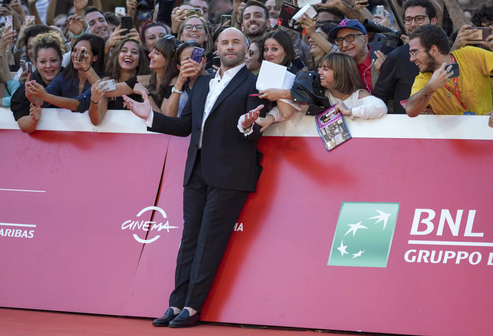 FILE- John Travolta poses with fans during a red carpet at the Rome Film Fest on Oct. 22, 2019, in Rome. Travolta turns 68 on Feb. 18. (AP Photo/Andrew Medichini, File)