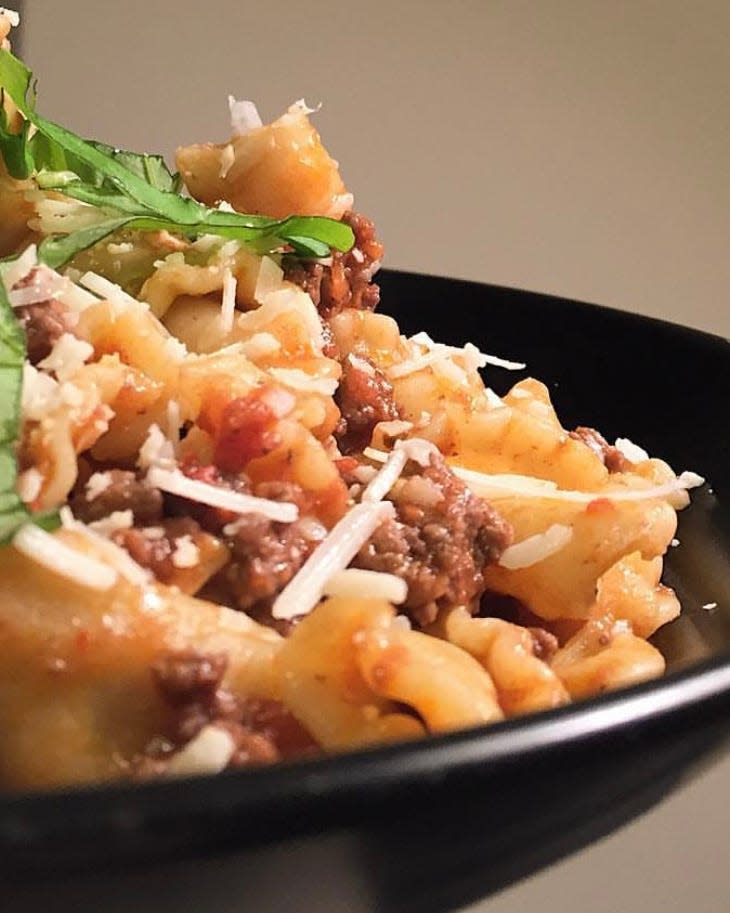 bolognese pasta with meat and shredded cheese