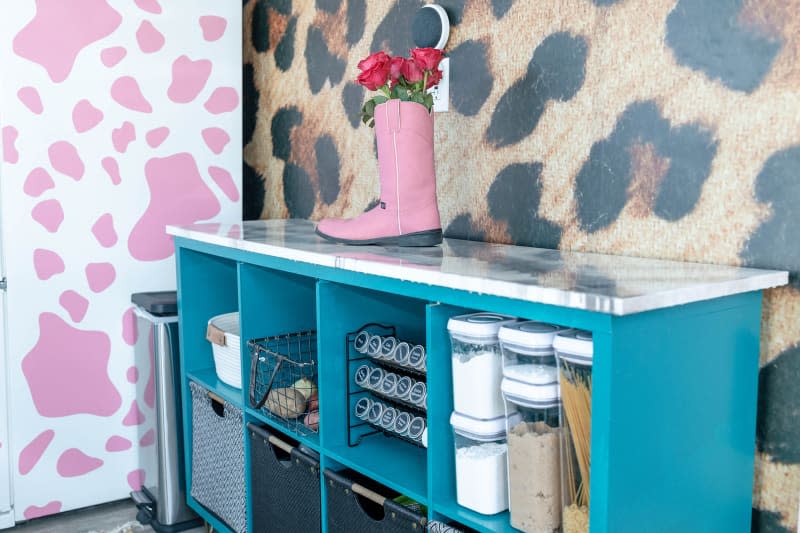 Turquoise shelves and pink and white cow-spot refrigerator in remodeled kitchen