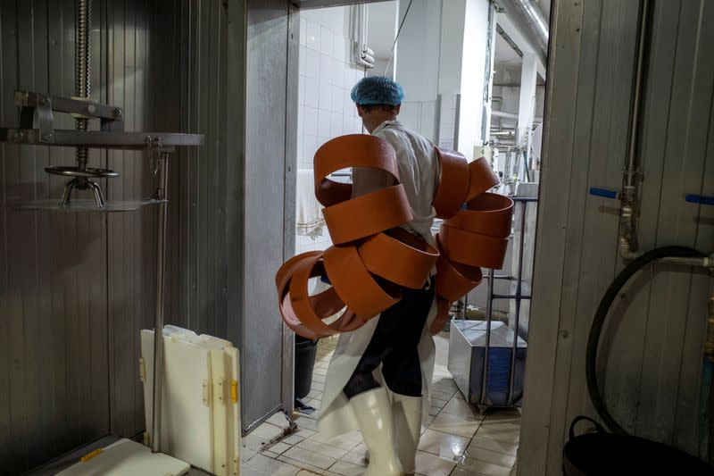 A worker carries plastic cheese molds at a milk processing factory on the island of Naxos