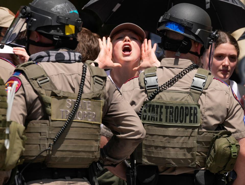 A pro-Palestinian protester yells from tight quarters with state troopers at UT.