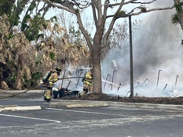 Firemen from the Sanibel Fire Rescue District spray water on what's left of the golf carts that caught on fire on Nov. 18, 2022 at The Dunes Golf and Tennis Club on Sanibel Island.