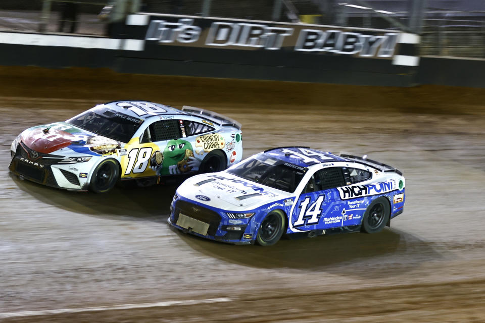 FILE - Driver Kyle Busch (18) races with Chase Briscoe (14) during a NASCAR Cup Series auto race, Sunday, April 17, 2022, in Bristol, Tenn. You might think it would help being a NASCAR driver who grew up dirt racing when it comes to Bristol Motor Speedway's relatively new dirt layout this Sunday night, April 9, 2023. (AP Photo/Wade Payne, File)