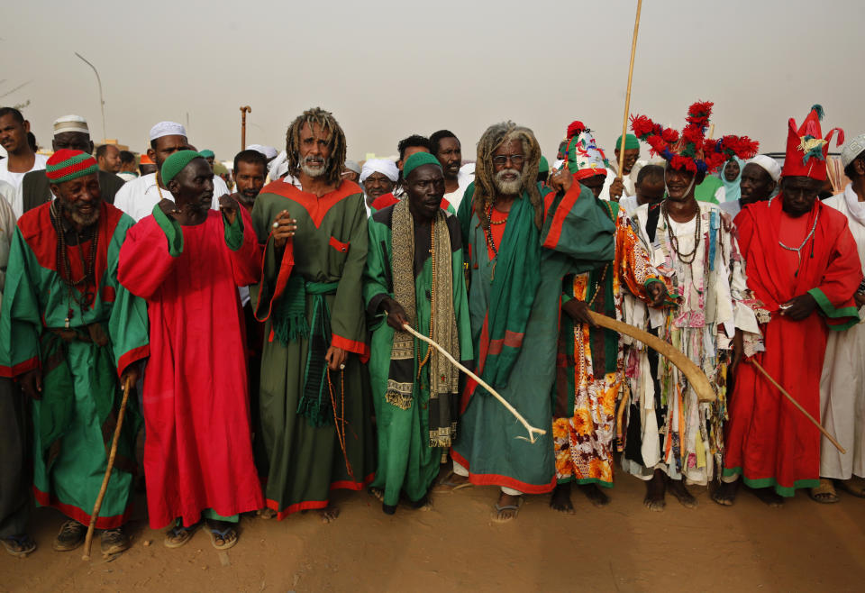 Adherents of the Qadiriyah sufi order, preform outside the tomb of Sheikh Hamed Al Nil, a 19th century Sufi leader, during a weekly gathering to dance and chant religious hymns until sunset, in the Omdurman district of Khartoum, Sudan, Friday, June 28, 2019. (AP Photo/Hussein Malla)