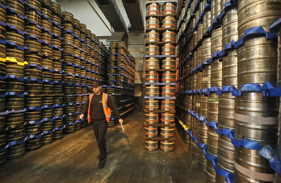 An employee walks past stored kegs of beer at Camerons Brewery in Hartlepool, England, Monday, Nov. 11, 2019. Political parties in Britain's Brexit-dominated December election are battling fiercely to win Hartlepool and places like it: working-class former industrial towns with voters who could hold the key to the prime minister's office at 10 Downing Street. (AP Photo/Frank Augstein)