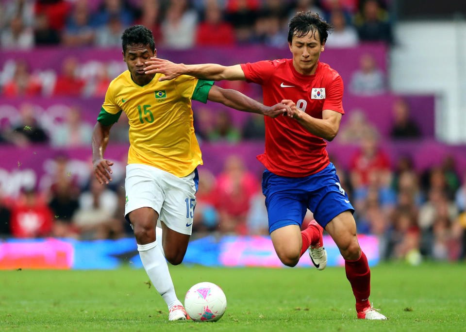 MANCHESTER, ENGLAND - AUGUST 07: Alex Sandro of Brazil holds off Ji Dongwon of Korea during the Men's Football Semi Final match between Korea and Brazil, on Day 11 of the London 2012 Olympic Games at Old Trafford on August 7, 2012 in Manchester, England. (Photo by Stanley Chou/Getty Images)