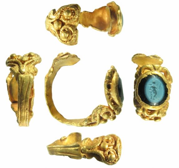 The ring's gold working is very intricate, including spiral designs and bead-shaped spheres.