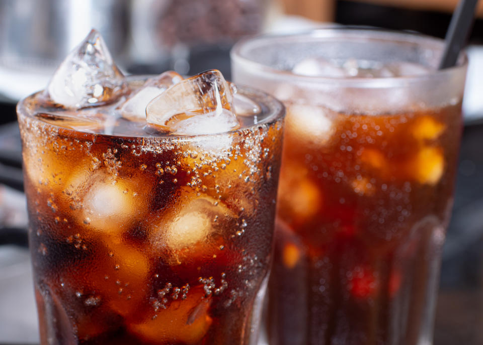 cola with crushed ice in glass and there is water droplets around