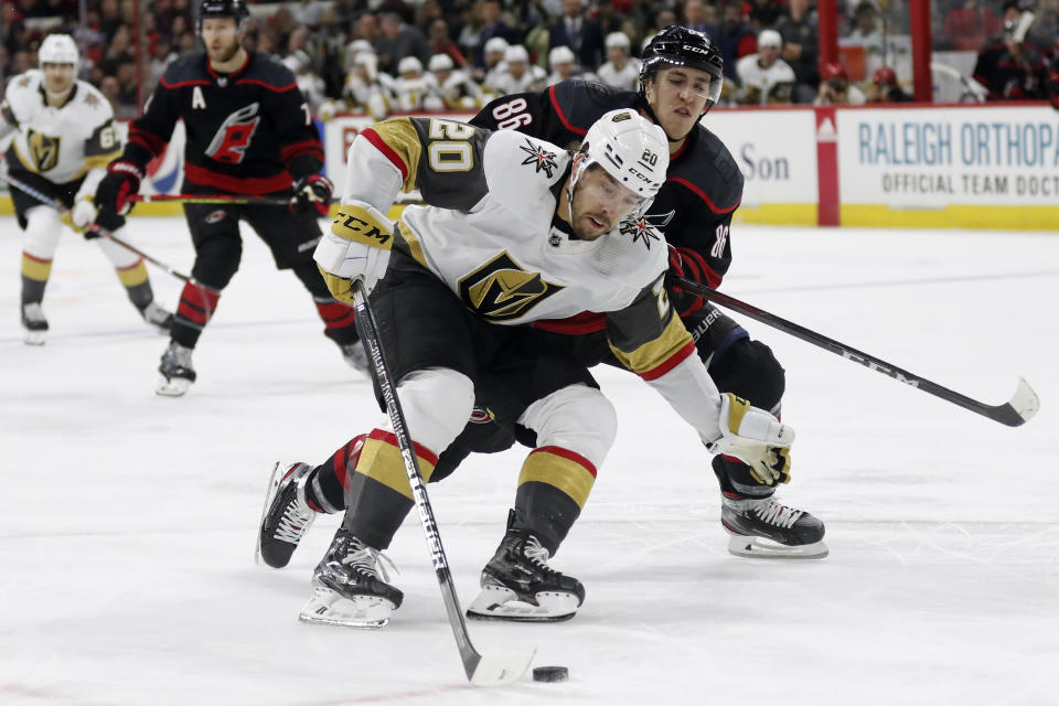 Vegas Golden Knights center Chandler Stephenson (20) controls the puck next to Carolina Hurricanes left wing Teuvo Teravainen (86), of Finland, during the third period of an NHL hockey game in Raleigh, N.C., Friday, Jan. 31, 2020. (AP Photo/Gerry Broome)