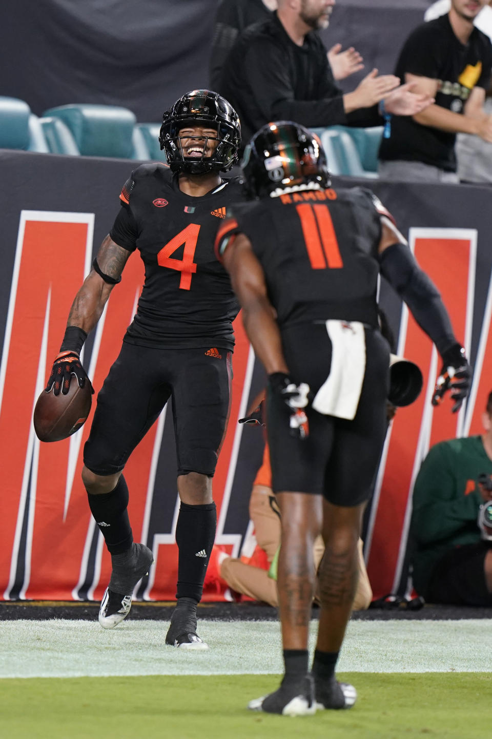 Miami running back Jaylan Knighton (4) celebrates a touchdown run with wide receiver Charleston Rambo (11) during the first half of the team's NCAA college football game against North Carolina State, Saturday, Oct. 23, 2021, in Miami Gardens, Fla. (AP Photo/Wilfredo Lee)