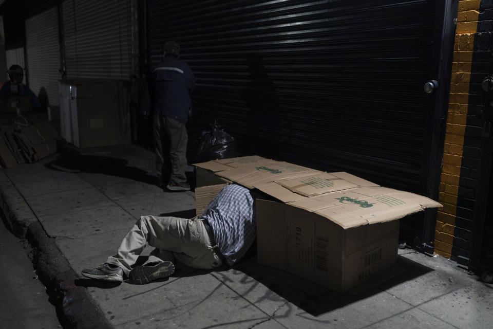 FILE - David Hernandez, a 62-year-old homeless man, crawls into his bed made with cardboard boxes in Los Angeles, late Wednesday, Dec. 14, 2022. President Joe Biden's Administration announced Monday, Dec. 19 it is ramping up efforts to help house people now sleeping on sidewalks, in tents and cars as a new federal report confirms what's obvious to people in many cities: Homelessness is persisting despite increased local efforts. (AP Photo/Jae C. Hong, File)