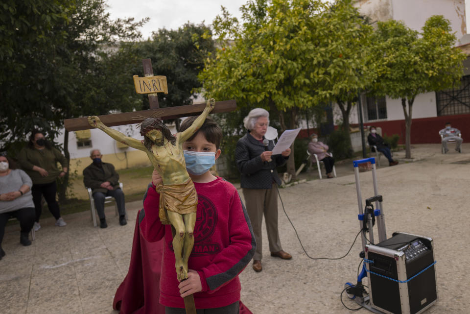 Catholic worshipers attend a religious event outside Nuestra Senora de la Candelaria church in Seville, southern Spain, Friday, Feb. 26, 2021. Few Catholics in devout southern Spain would have imagined an April without the pomp and ceremony of Holy Week processions. With the coronavirus pandemic unremitting, they will miss them for a second year. (AP Photo/Laura Leon)