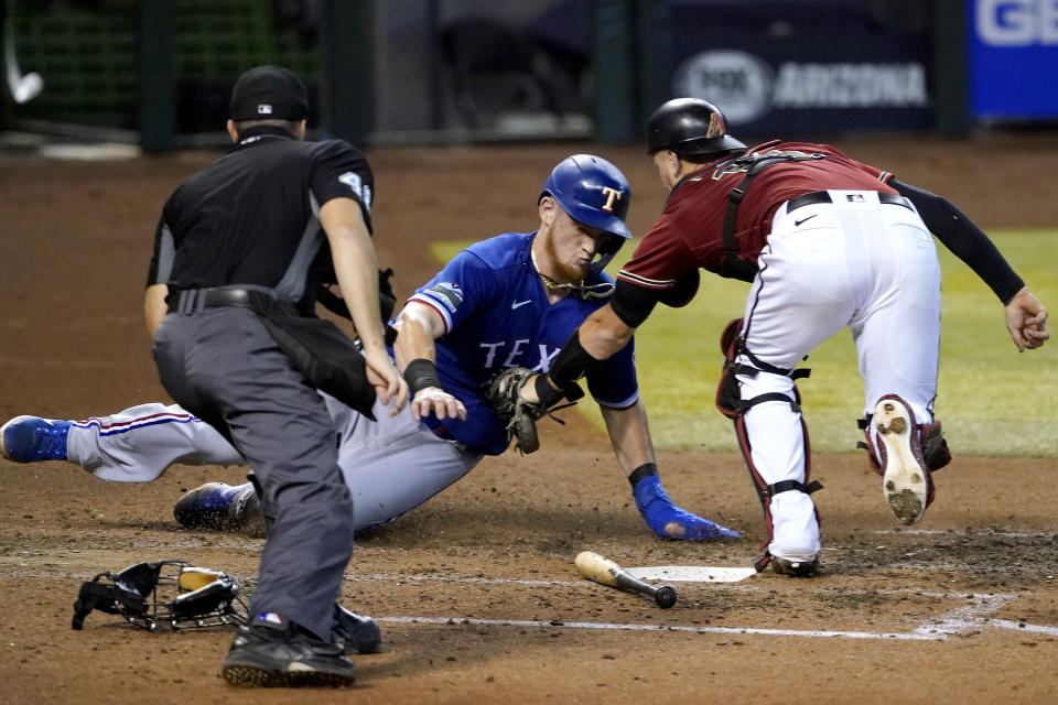 Texas Rangers' Sam Huff is tagged out at the plate by Arizona Diamondbacks catcher Carson Kelly while trying to score on a fielders choice hit by teammate Anderson Tejeda during the sixth inning of a baseball game, Wednesday, Sept. 23, 2020, in Phoenix. (AP Photo/Matt York)