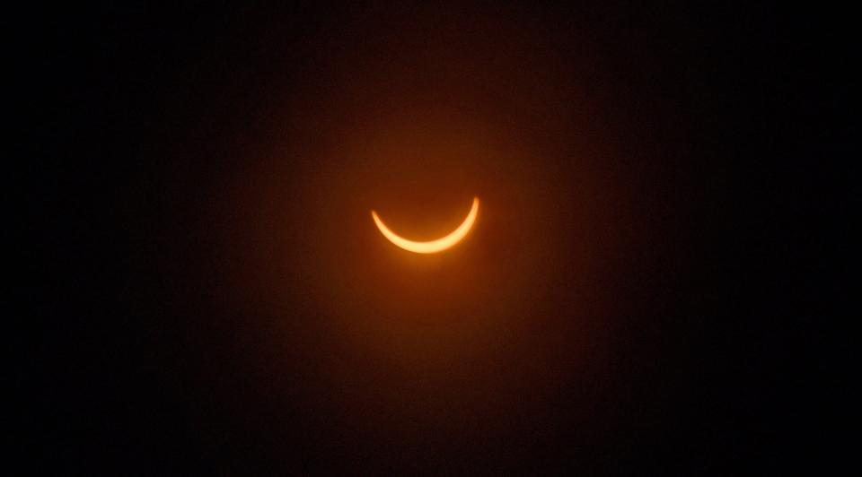 At 2:49 p.m. on Aug. 21, 2017, a partial solar eclipse is seen through a camera lens filter as the clouds break through over the University of North Florida in Jacksonville.