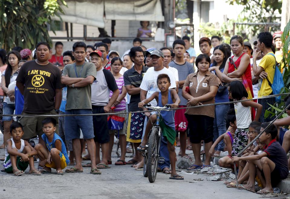 Residents wait for the retrieval of their family members who were killed during a fire at a slipper factory in Valenzuela