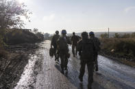 A group of Ukrainian servicemen walk along a road close to the frontline near Bakhmut, Donetsk region, Ukraine, Saturday, Sept. 16, 2023. The General Staff of Ukraine's armed forces announced the reclaiming of the village of Andriivka, 10 kilometers (6 miles) south of Russian-occupied city of Bakhmut on Friday. (AP Photo/Alex Babenko).