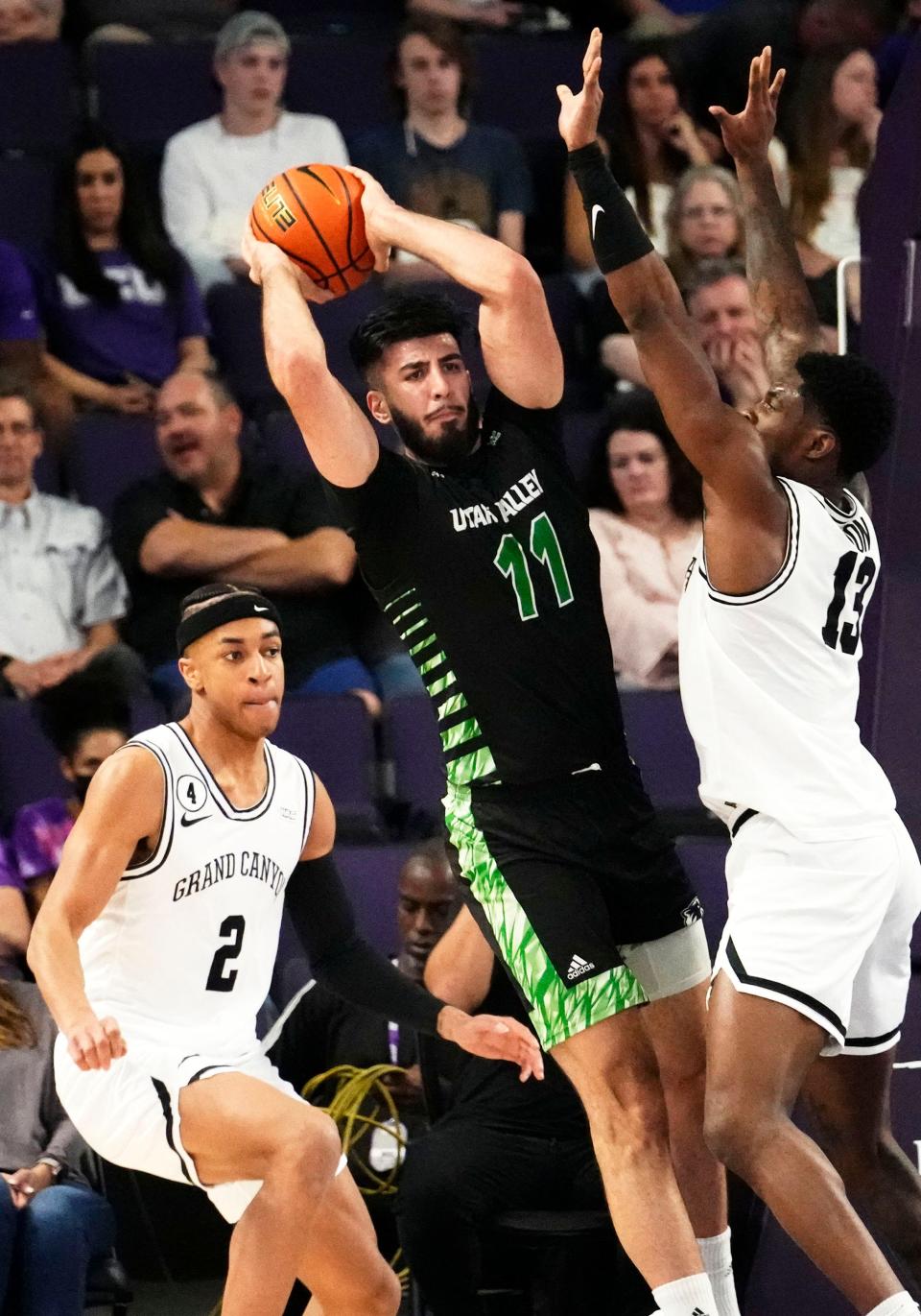 Mar 3, 2022; Phoenix, Arizona, USA; Utah Valley Wolverines center Fardaws Aimaq (11) is pressured by Grand Canyon Antelopes forward Aidan Igiehon (13) at GCU Arena. Mandatory Credit: Rob Schumacher-Arizona Republic