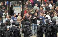 Protesters gather for a far-right protest in front of a Karl Marx monument in Chemnitz, Germany, Monday, Aug. 27, 2018 after a man has died and two others were injured in an altercation between several people of "various nationalities" in the eastern German city of Chemnitz on Sunday. (AP Photo/Jens Meyer)