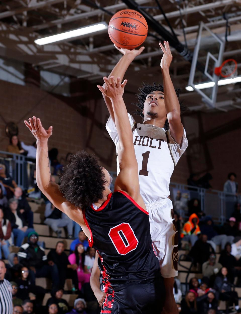 Holt's Donye Thomas, right, shoots over Sexton's Mario Murray, Tuesday, Nov. 28, 2023, in Holt. Holt won 57-54.