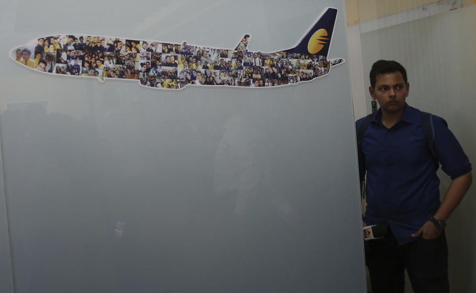 A reporter stands at the Jet Airways headquarters in Mumbai, India Thursday, April 18, 2019. Jet Airways, once India's largest airline, announced on Wednesday that it is suspending all operations after failing to raise enough money to run its services. (AP Photo/Rafiq Maqbool)