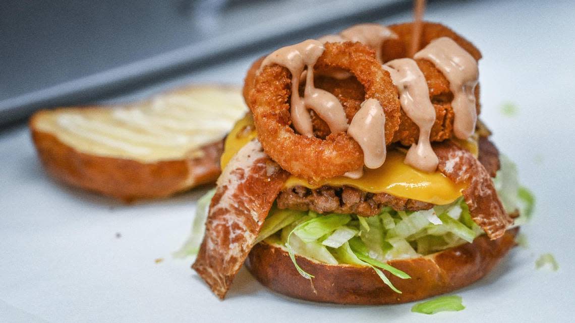 A vegan campfire burger made with plant-based beef, bacon, cheese and onion rings is prepared at Plant Slayer, a comfort food vegan restaurant now in the Galleria in downtown Fresno on Wednesday, Aug. 10, 2022.