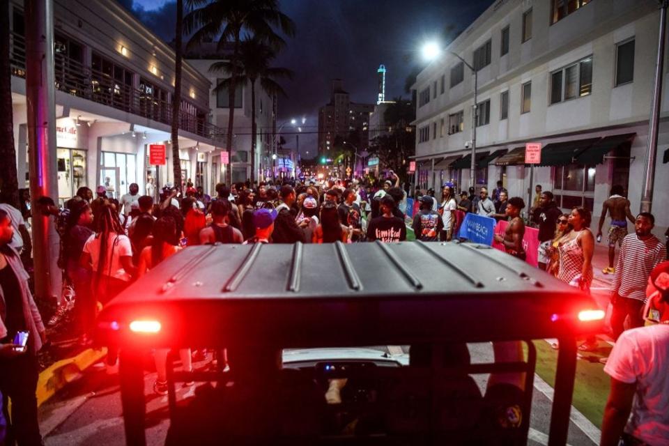 Miami Beach Police escort revelers as they gather on Ocean Drive in Miami Beach, Florida on March 15, 2022.