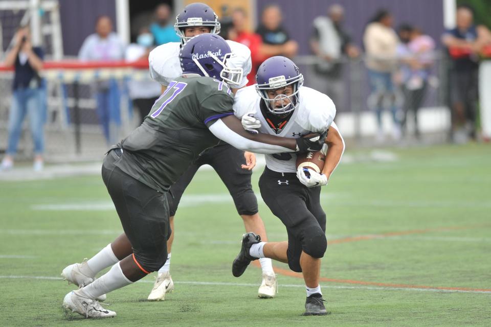 Mt. Hope's Brock Pacheco tries to escape a tackle by Classical defensive lineman Tosin Akinsulire during a game last season.