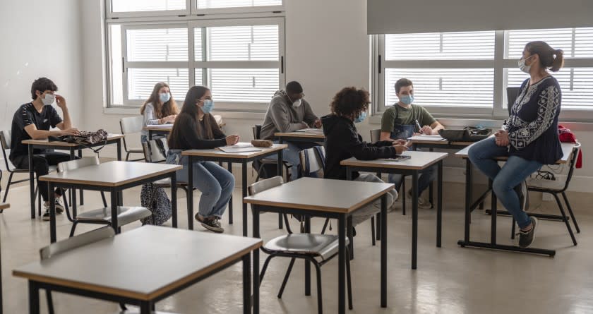 CASCAIS, PORTUGAL - MAY 18: High school students and their teacher wear mandatory protective masks during class in the Agrupamento de Escolas Frei Gonçalo de Azevedo during the COVID-19 Coronavirus pandemic on May 18, 2020 in Cascais, Portugal. 200.000 students are returning to school in Portugal today as part of new and more relaxed measures adopted by the government after the country's state of emergency was downgraded to state of calamity permitting certain non-essential services and commercial activities to resume as the coronavirus (COVID-19) epidemic appears to be under control. (Photo by Horacio Villalobos#Corbis/Corbis via Getty Images)