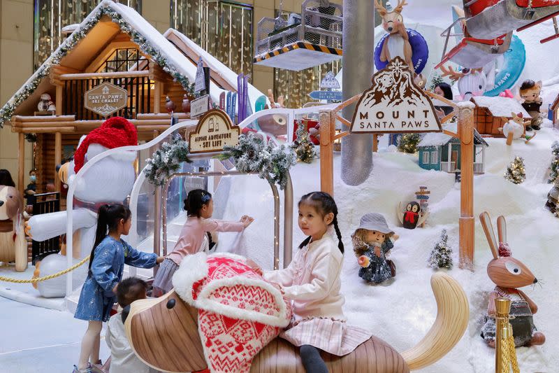 A child poses for a photo with Christmas decorations at Landmark, the upscale shopping mall, in Hong Kong