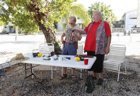 Doug Varrieur (L) and Huie Gordon, his friend, neighbor and retired Monroe County Sheriff's Deputy prepare to practice their firing stances with unloaded weapons in the yard of Varrieur's home in Big Pine Keys in the Florida Keys March 5, 2014. REUTERS/Andrew Innerarity