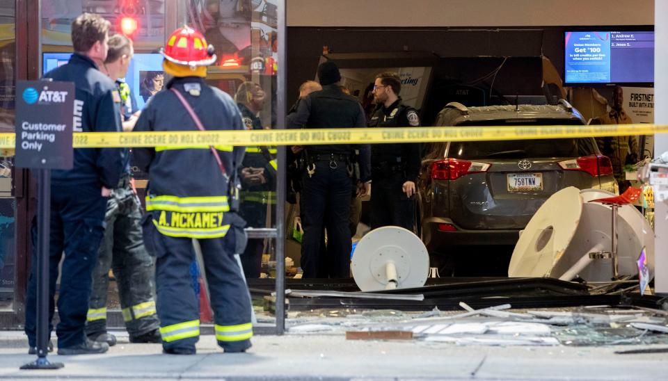 Emergency responders work the scene where a vehicle crashed into an AT&T store Monday, Nov. 29, 2021, near the intersection of Georgetown and Lafayette roads in Indianapolis.