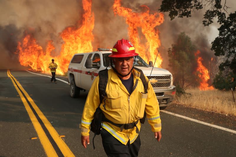 Firefighter monitors LNU Lightning Complex Fire as it engulfs brush in Lake County, California