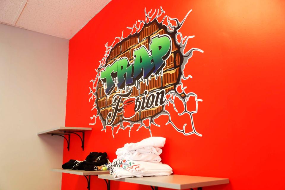 T-shirts and the logo of the restaurant can be seen on the wall inside of the dining area of Trap Fusion on Wednesday, December 13, 2023 at 670 N Germantown Parkway in Cordova, Tenn.