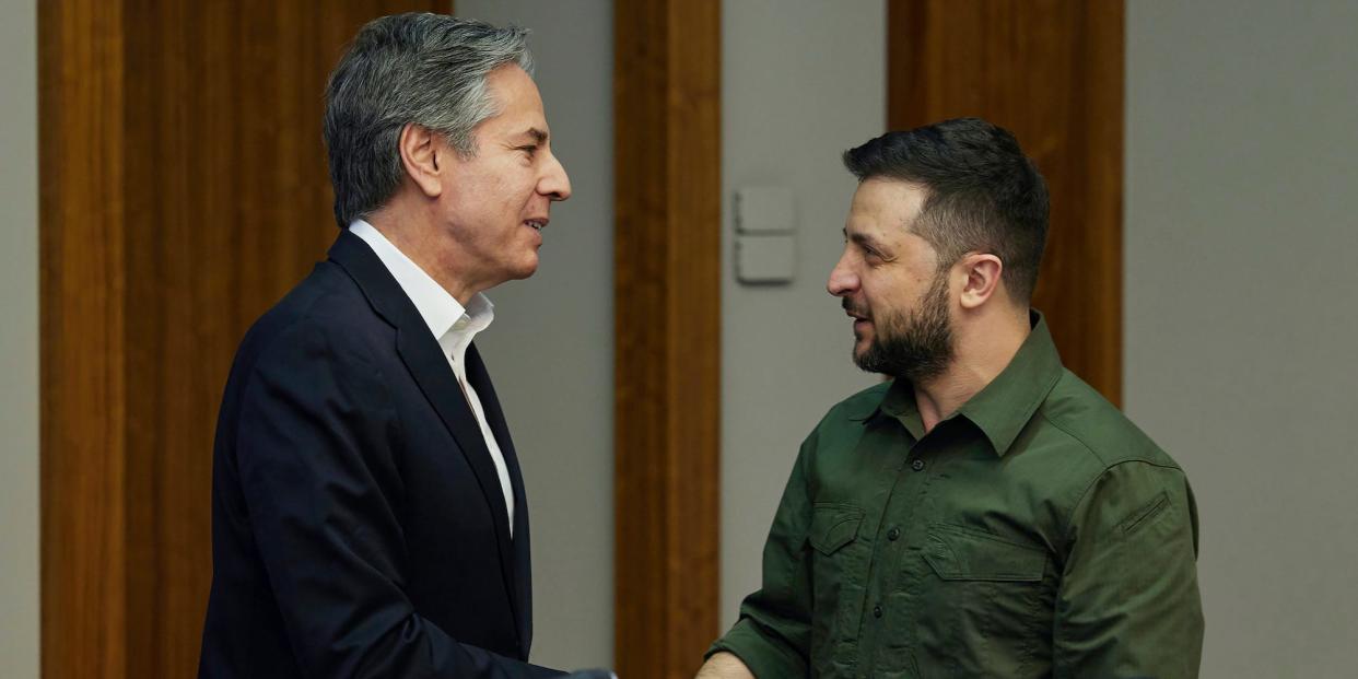 Volodymyr Zelenskyy and Antony Blinken shake hands