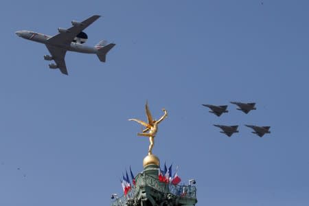 FILE PHOTO: A Boeing AWACS 1E-3F and Mirage 2000 jet fighters fly past the "Genie de la Liberte"gilded figure (Spirit of Freedom) on top of the Place de la Bastille's July Column in Paris