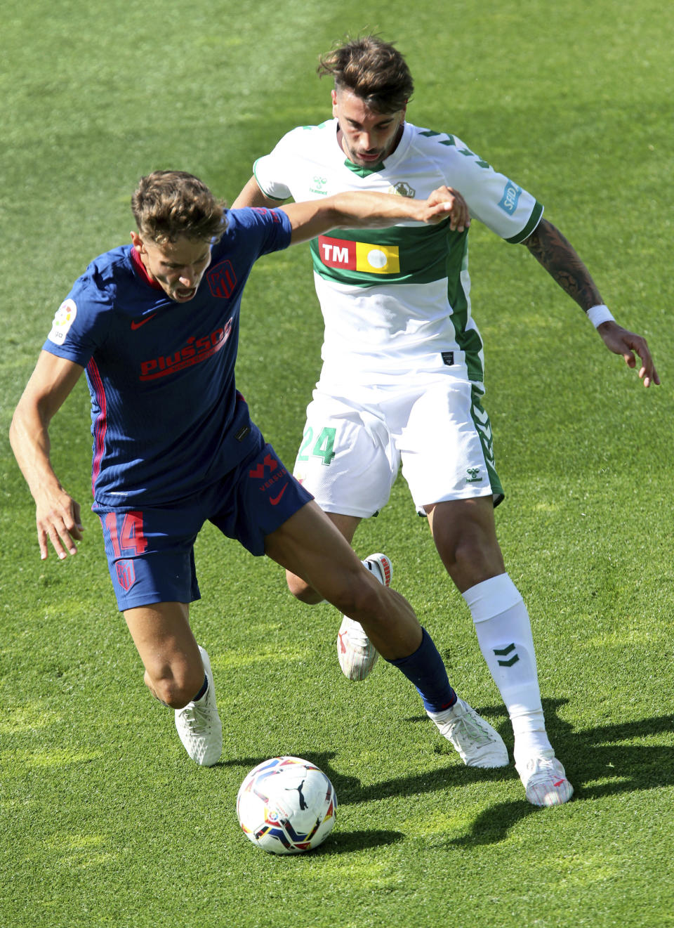 Marcos Llorente del Atlético Madrid, izquierda, disputa un balón con Josema, de Elche, en partido de la liga española, sábado 1 de mayo de 2021. Atlético ganó 1-0 con gol de Llorente y se afianzó en la punta de la tabla. (AP Foto/Alberto Saiz)