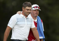 Bryson DeChambeau, left, of the United States is comforted by his caddie Tim Tucker, after he bogeyed on the 17th hole during the WGC-Mexico Championship golf tournament, at the Chapultepec Golf Club in Mexico City, Sunday, Feb. 23, 2020. (AP Photo/Fernando Llano)