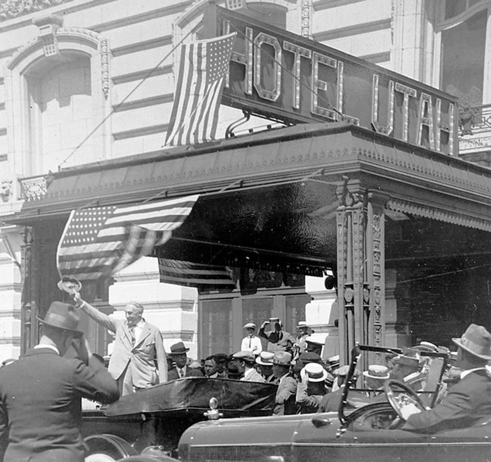 President Warren G. Harding waving to crowd in front of the Hotel Utah. Sen. Reed Smoot and Gov. Charles R. Mabey are behind him. | Ron Fox