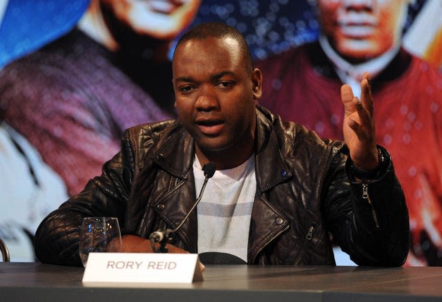 Rory Reid sitting behind microphone wearing a leather jacket