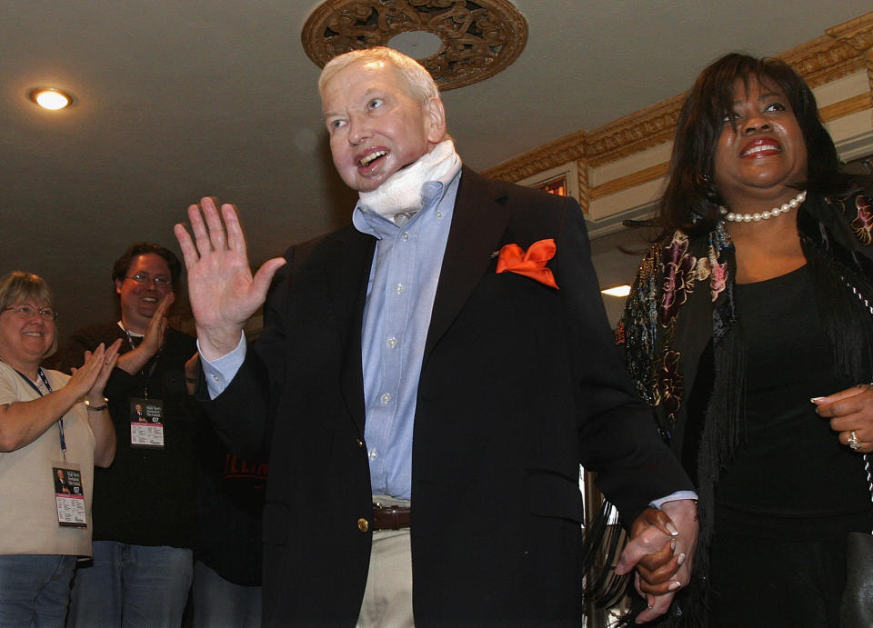 FILE - In this April 25, 2007 file photo, film critic Roger Ebert holds the hand of his wife, Chaz, as he enters the Virginia Theatre for his annual film festival in Champaign, Ill. A bronze statue showing Ebert giving his famous "thumbs up" sign is to be unveiled Thursday, April 24, 2014, during Ebertfest in front of the theater. Ebert died in April 2013. (AP Photo/Seth Perlman, File)