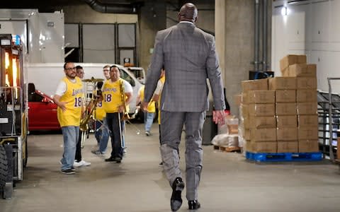 Magic Johnson walks toward members of the Los Angeles Lakers' band as he leaves the building - Credit: AP