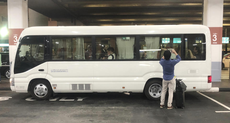 A Japanese journalist takes a photograph of mariners from the MT Front Altair in a bus after they left Dubai International Airport in Dubai, United Arab Emirates, on Saturday, June 15, 2019, after spending two days in Iran. Associated Press journalists saw the crew members of the MT Front Altair on Saturday night after their Iran Air flight from Bandar Abbas, Iran, landed in Dubai in the United Arab Emirates. The Norwegian-owned oil tanker was attacked Thursday, June 13, in the Gulf of Oman. The U.S. has accused Iran of attacking the Front Altair and another oil tanker with limpet mines. Iran has denied the allegations. (AP Photo/Jon Gambrell)