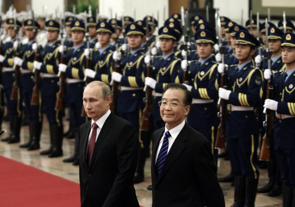 Russian Prime Minister Vladimir Putin, left, and Chinese Premier Wen Jiabao, right, inspect a guard of honor during a welcoming ceremony at the Great Hall of the People in Beijing, China on Tuesday, Oct. 11, 2011. (AP Photo/Jason Lee, Pool)