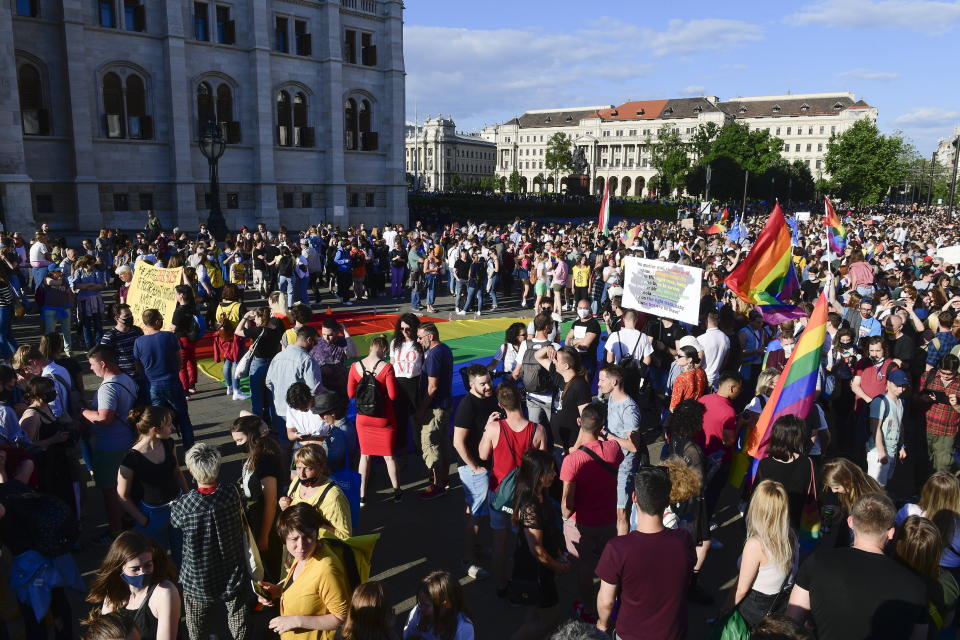 People gather during an LGBT rights demonstration in front of the Hungarian Parliament building in Budapest, Hungary on June. 14, 2021. During the protest human rights activists called on lawmakers in Hungary to reject legislation banning any content portraying or promoting homosexuality or sex reassignment to anyone under 18. The bills, aiming at fighting pedophilia, have various amendments which would outlaw any depiction or discussion of different gender identities to youth in the public sphere. (Szilard Koszticsak/MTI via AP)