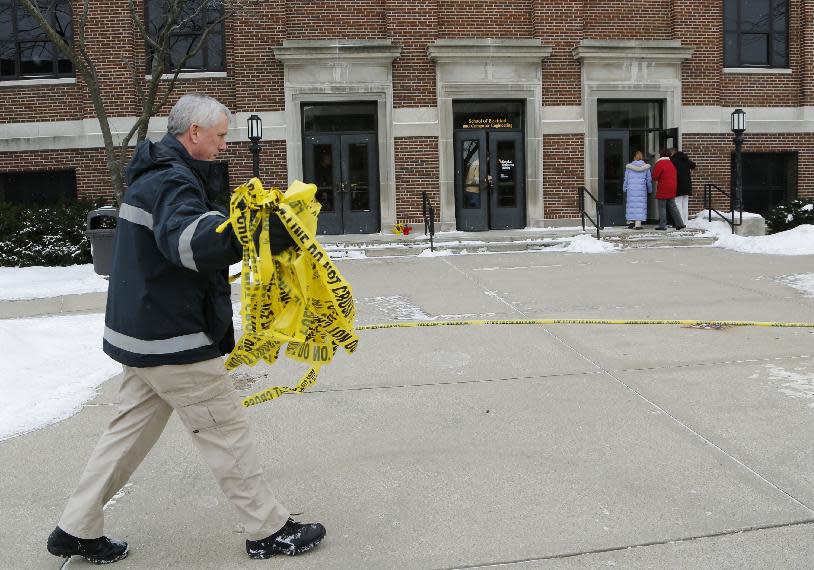 Kevin Luse of Purdue University Fire Department collects police tape as the Electrical Engineering building is opened, Wednesday, January 22, 2014, on the campus of Purdue University, in West Lafayette, Ind. The building had been closed since engineering student Andrew Boldt was shot and killed Tuesday. Cody Cousins, a student, has been charged in the shooting. (AP Photo/Journal & Courier, John Terhune)