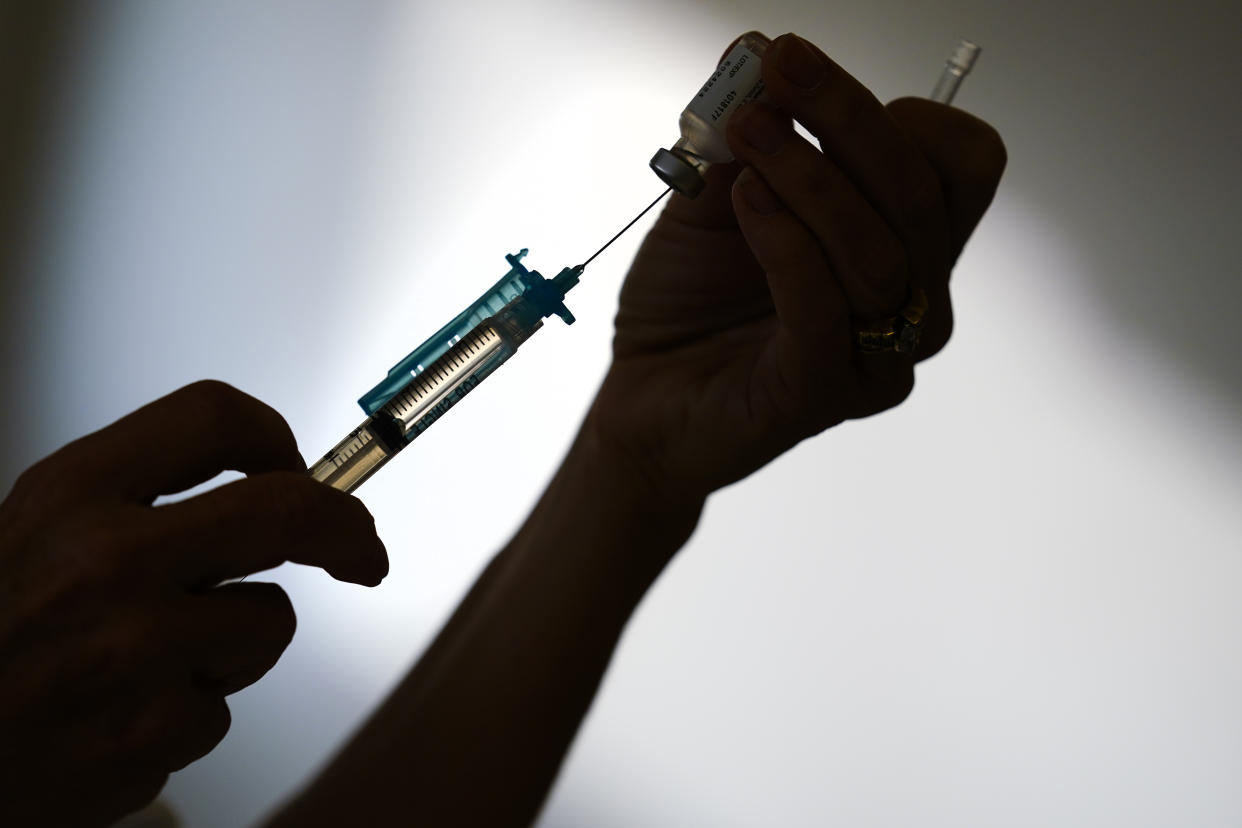 FILE - A syringe is prepared with the Pfizer COVID-19 vaccine at a clinic in the Norristown Public Health Center in Norristown, Pa., Tuesday, Dec. 7, 2021. The nation’s COVID-19 death toll stands at around 800,000 as the anniversary of the U.S. vaccine rollout arrives. A year ago it stood at 300,000. What might have been a time to celebrate a scientific achievement is fraught with discord and mourning. (AP Photo/Matt Rourke, File)