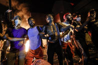 In this image released by World Press Photo, Thursday April 15, 2021, by John Minchillo, Associated Press, part of a series titled Minneapolis Unrest: The George Floyd Aftermath, which won third prize in the Spot News Stories category, shows Protesters join arms in defiance during a demonstration outside the burning Minneapolis Police Department 3rd Precinct building, in Minneapolis, Minnesota, USA, on 28 May 2020. (John Minchillo, Associated Press, World Press Photo via AP)