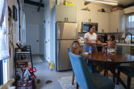 Josephine Fraser, 22, born and raised in Lahaina, stands with her sons Ireh Dias, 3, at left, and Zyon Dias, 18 months, right, in their small home at Ke Ao Maluhia at the Maui Lani housing development, spearheaded by the Council for Native Hawaiian Advancement, Wednesday, July 10, 2024, in Kahului, Hawaii. The family has moved 10 times over the past 11 months after being displaced by the 2023 wildfire and are the first to move into the modular home community being built for those affected. (AP Photo/Lindsey Wasson)