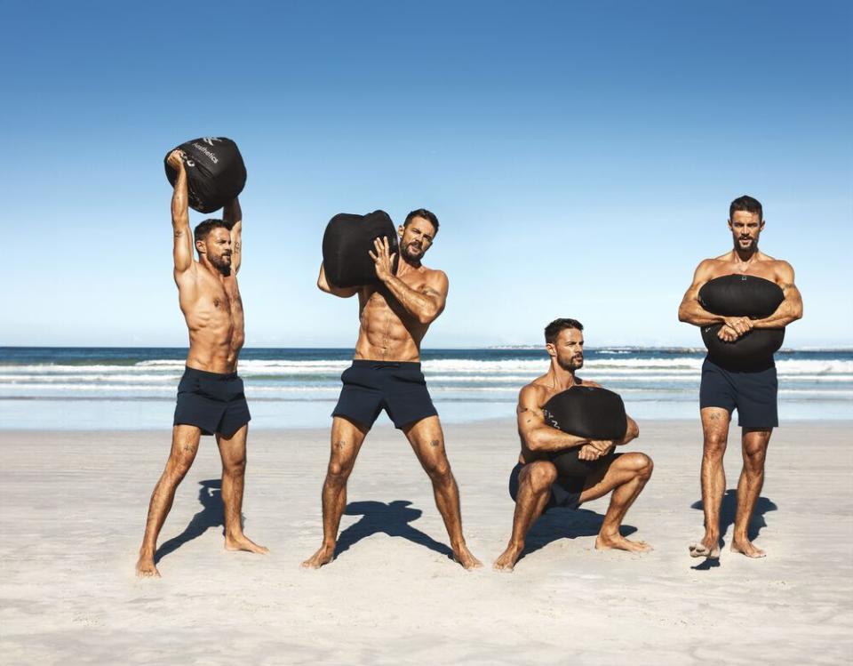 a group of men working out on a beach